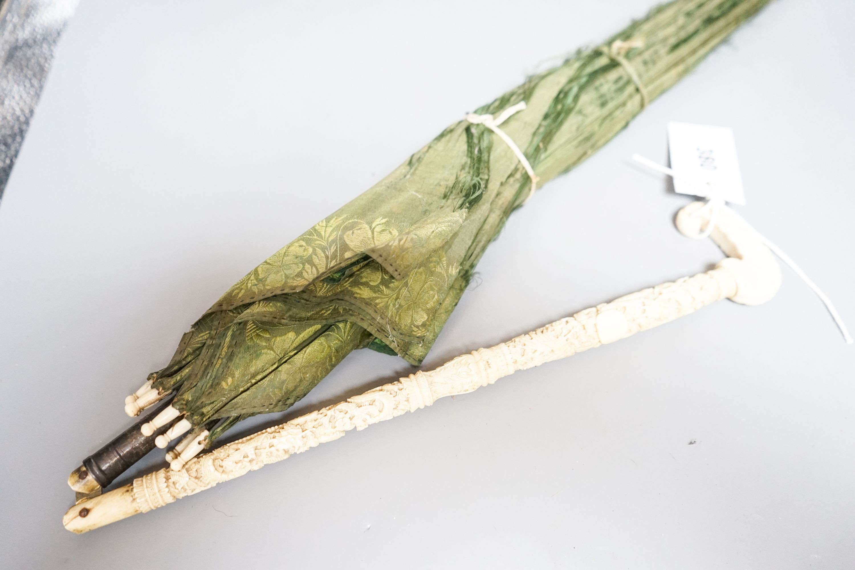 A 19th century Chinese Canton export ivory parasol with carved Ivory handle and a Burmese white metal handled painted fabric parasol